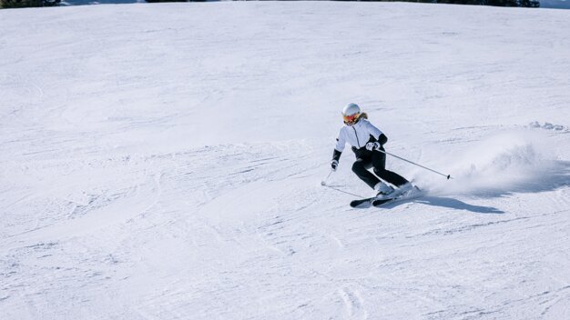 Skifahrerin fährt einen verschneiten Hang hinunter. | © IIC - INTERSPORT International Corporation GmbH