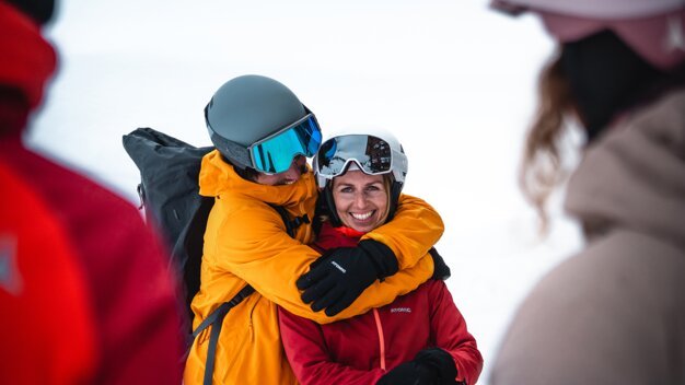 A couple in ski gear embracing in the snow. | © Atomic Austria GmbH