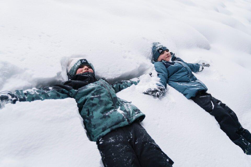 © INTERSPORT International Corporation GmbH Two children making snow angels in the snow. | © INTERSPORT International Corporation GmbH