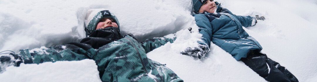 Twee kinderen maken sneeuwengelen in de sneeuw. | © INTERSPORT International Corporation GmbH