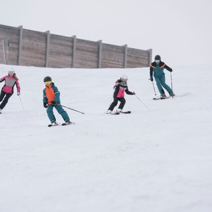 Vier skiërs op een besneeuwde helling. | © IIC/McKINLEY