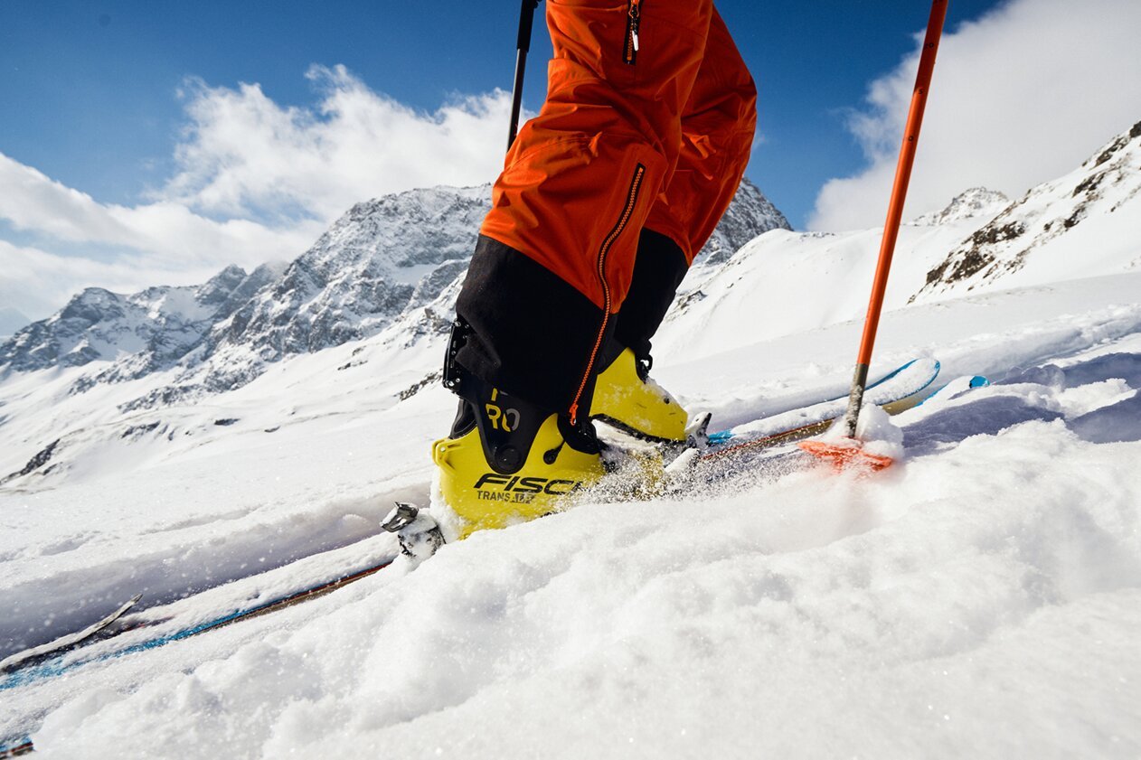 Skieur en chaussures de ski jaunes skiant dans la neige | © Fischer Sports GmbH