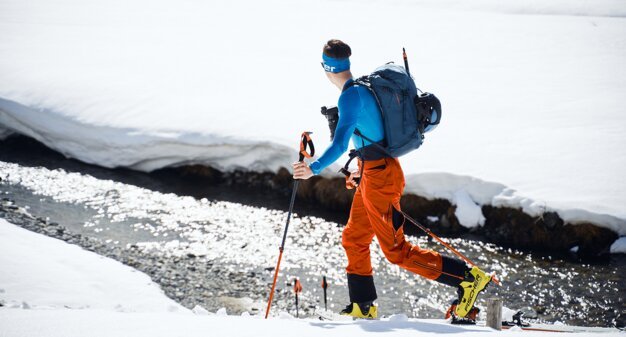 Skier with backpack crossing snowy landscape. | © Fischer Sports GmbH