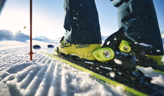 Skieur avec des chaussures de ski jaunes sur une piste enneigée. | © Fischer Sports GmbH