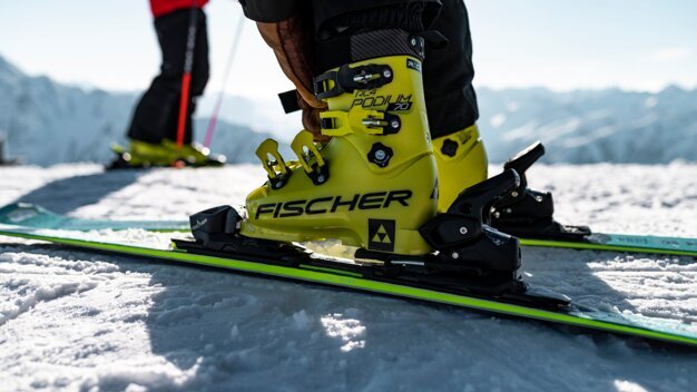 Chaussures de ski Fischer jaunes sur des skis dans la neige. | © Fischer Sports GmbH