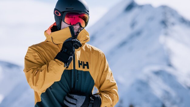 © IIC - INTERSPORT International Corporation GmbH Skier wearing helmet and goggles in front of mountain backdrop | © IIC - INTERSPORT International Corporation GmbH