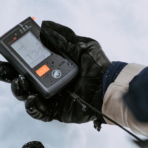 Main gantée tenant un émetteur-récepteur d'avalanche Barryvox | © Mammut Archive