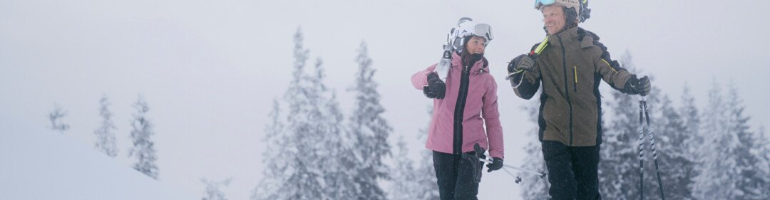 © INTERSPORT International Corporation GmbH Twee skiërs lopen door een besneeuwd landschap. | © INTERSPORT International Corporation GmbH