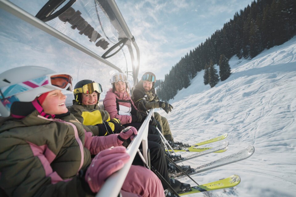 © INTERSPORT International Corporation GmbH Familie fährt Ski-Lift an einem sonnigen Tag. | © INTERSPORT International Corporation GmbH
