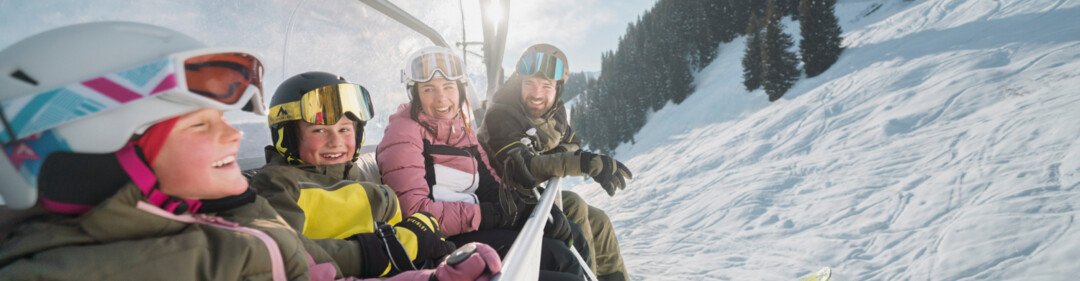 Familie in een skilift op een zonnige dag. | © INTERSPORT International Corporation GmbH