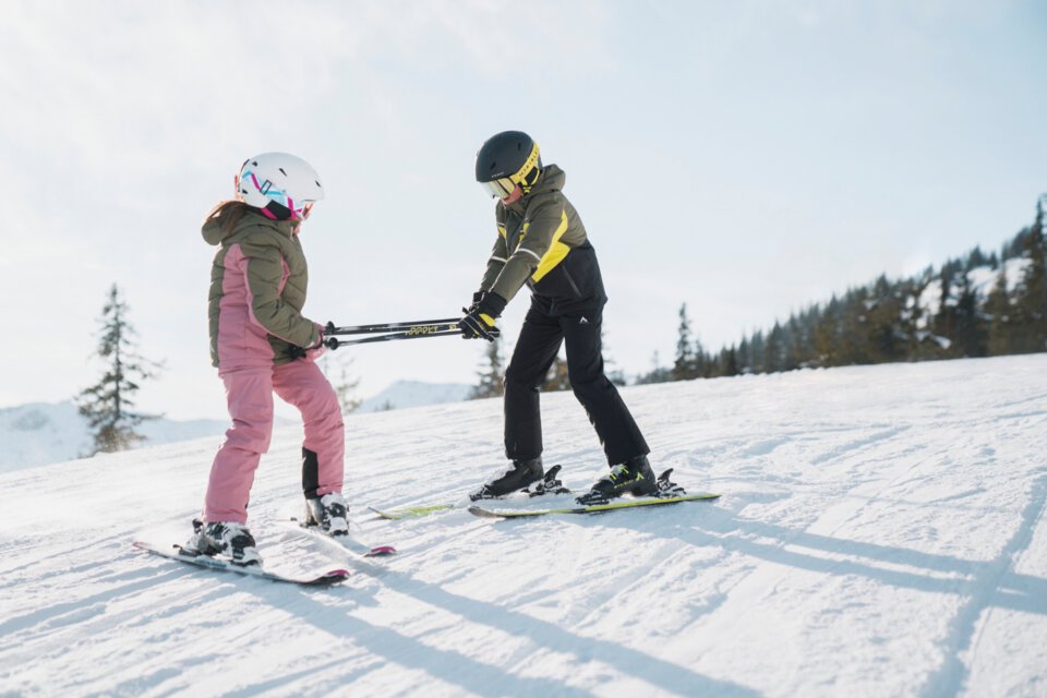 © INTERSPORT International Corporation GmbH Zwei Kinder beim Skifahren auf einer Skipiste. | © INTERSPORT International Corporation GmbH