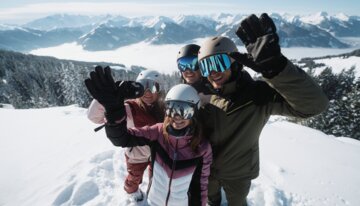 Groep van vier skiërs zwaait in de bergen. | © INTERSPORT International Corporation GmbH