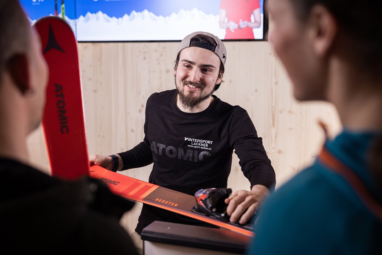 Salesperson with Atomic brand skis in a sports shop | © IIC - INTERSPORT International Corporation GmbH