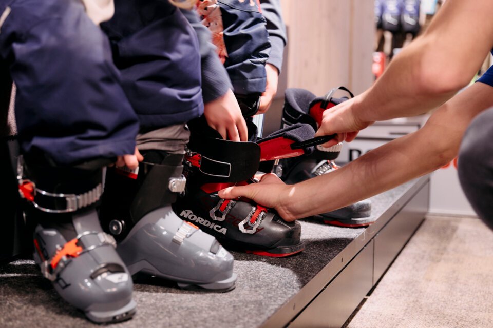 © ARMIN WALCHER Kinder, die Skischuhe anprobieren. | © ARMIN WALCHER