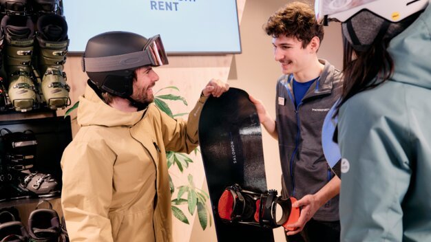 Homme avec un snowboard dans un magasin Intersport. | © ARMIN WALCHER
