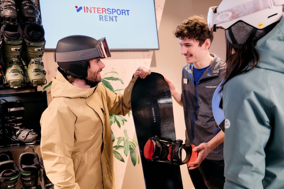 © ARMIN WALCHER Homme avec un snowboard dans un magasin Intersport. | © ARMIN WALCHER