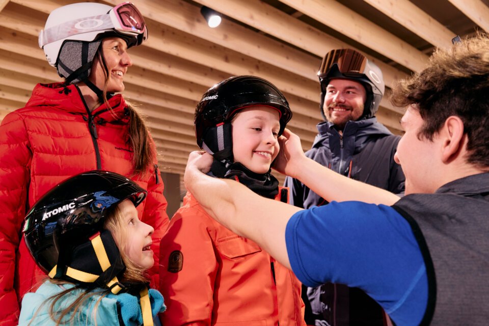 © ARMIN WALCHER Familie probiert Skihelme in einem Geschäft. | © ARMIN WALCHER