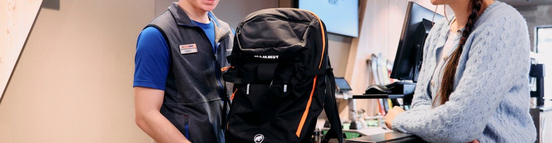 Verkoper toont een Mammut rugzak aan een klant in een sportwinkel. | © ARMIN WALCHER