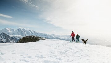 Two skiers with a dog in a snowy mountain landscape. | © Florian Monot / ROSSIGNOL