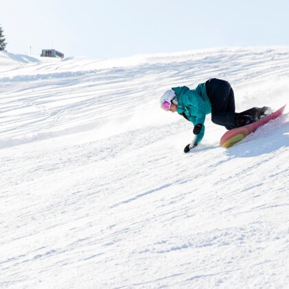 Snowboarder riding down a snowy slope. | © Rossignol