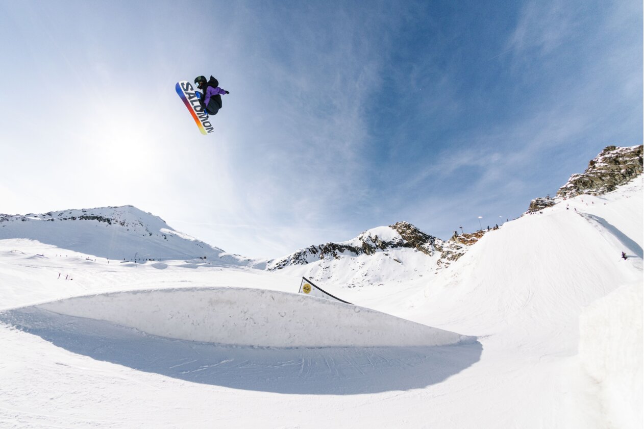 Snowboarder jumping off a ramp in the mountains. | © Salomon