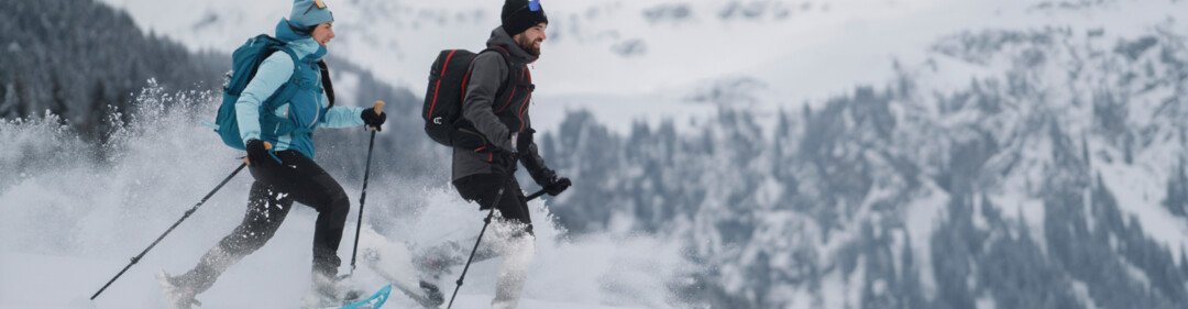 © INTERSPORT International Corporation GmbH Twee mensen aan het sneeuwschoenwandelen in een besneeuwd landschap. | © INTERSPORT International Corporation GmbH