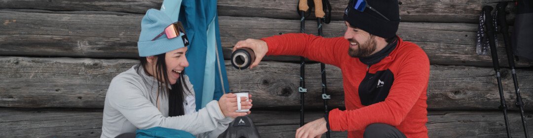 Twee mensen nemen een pauze van sneeuwschoenwandelen, drinken koffie. | © INTERSPORT International Corporation GmbH