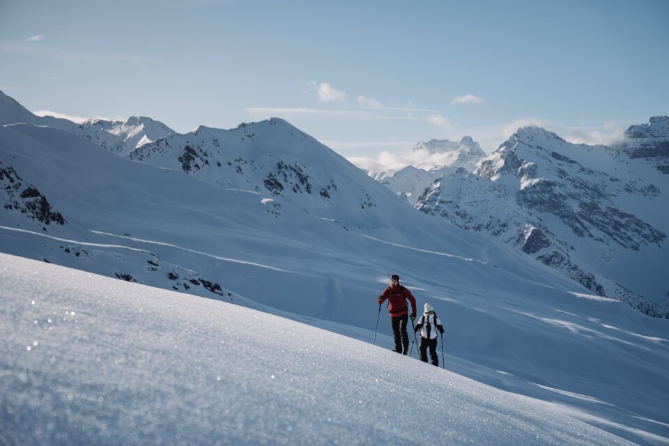 © INTERSPORT International Corporation GmbH Zwei Personen beim Skitourengehen in verschneiter Berglandschaft. | © INTERSPORT International Corporation GmbH