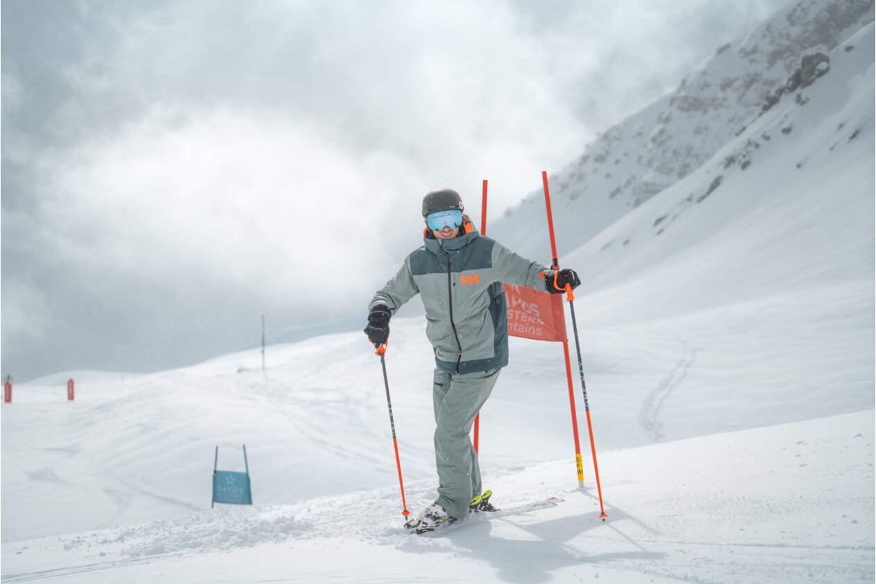 Skier on a snowy slope with slalom poles.