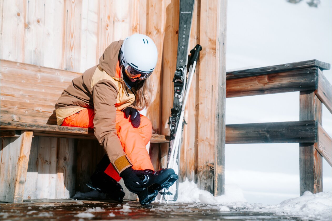 Skier putting on ski boots.