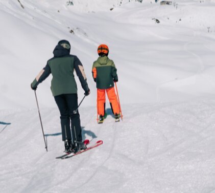 Quatre personnes font du ski sur une piste de ski.