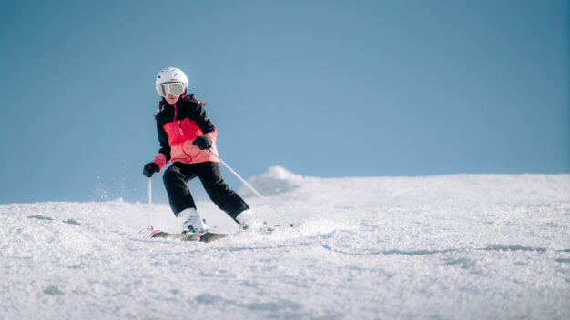 Enfant skiant sur une piste enneigée.
