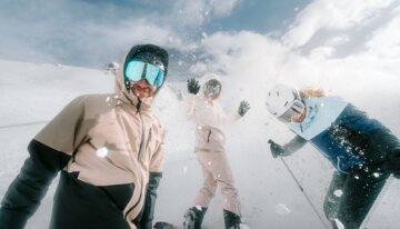 Groep van drie mensen aan het skiën in de sneeuw.