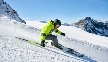Skieur dévalant une pente enneigée