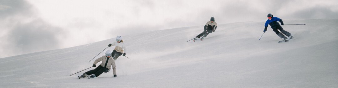 Quatre skieurs sur une piste enneigée