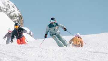 A family skiing down a snowy slope.