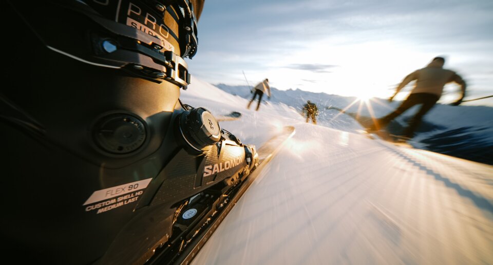 Chaussure de ski et ski en mouvement sur une piste enneigée