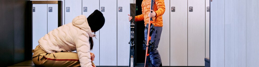 © ARMIN WALCHER Twee mensen bereiden zich voor op het skiën in een skiruimte. | © ARMIN WALCHER