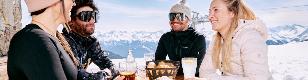 Groep vrienden eet in een skihut. | © ARMIN WALCHER