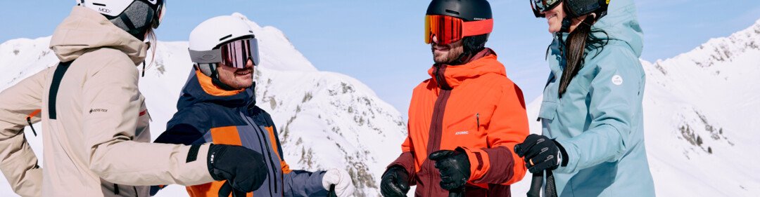 Vier skiërs praten met elkaar in de sneeuw. | © ARMIN WALCHER