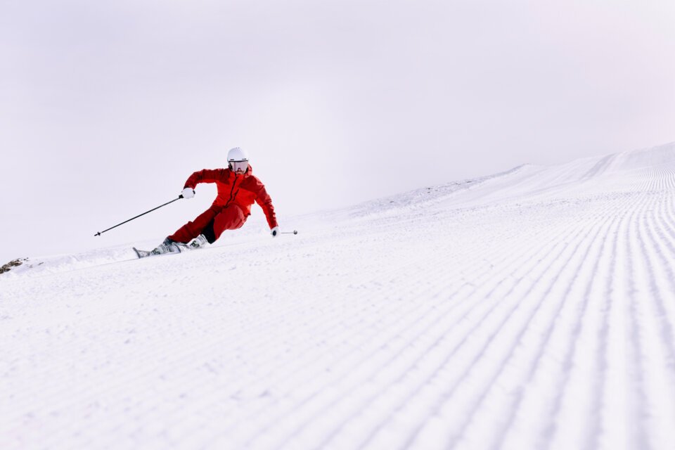 © ARMIN WALCHER Skier in red outfit on snowy piste. | © ARMIN WALCHER