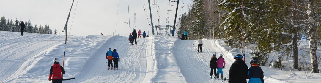 Skiërs die een sleeplift gebruiken op een besneeuwde helling.