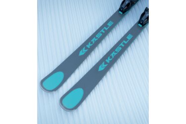 Une paire de skis gris avec des accents turquoise sur la neige.