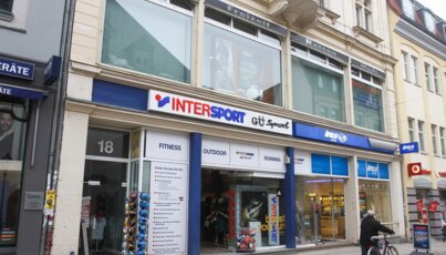 Facade of an Intersport sports store and Apollo Optik.